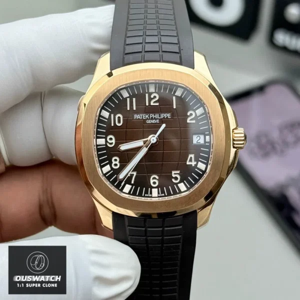 Handheld front view of the Super Clone Patek 5167R Aquanaut watch, featuring a rose gold case, brown dial, and brown rubber strap