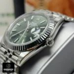 Side close-up of the Super Clone Rolex Datejust Green watch placed on a watch stand