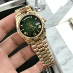 Top Replica Gold Rolex Green Face Day Date 40 Watch displayed at a 120-degree angle, focusing on the striking green dial and premium yellow gold case.