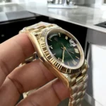 Top Replica Gold Rolex Green Face Day Date 40 Watch side view, showcasing the elegant yellow gold case and signature green dial.