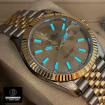 Replica Rolex Datejust Two Tone 126333 Watch displayed at night, highlighting the luminous markers and hands on the champagne dial.