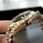 Top Replica Rolex Day Date Yellow Gold 228238 Watch, close-up of the crown, highlighting the classic design and luxurious gold finish.