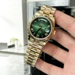 Top Replica Rolex Green Face Day Date 40 m228238 Watch displayed at a 75-degree angle, showcasing the elegant green ombré dial and yellow gold case.