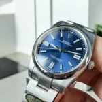Replica Rolex Oyster Perpetual Date m124300 watch, featuring a close-up view of the blue dial and Oystersteel case, blending style and durability effortlessly.