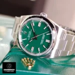 Replica Rolex Oyster Perpetual Green m124300 watch displayed above the box, showcasing the stunning green dial and elegant design.