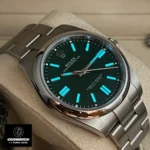 Replica Rolex Oyster Perpetual Green m124300 watch in a night display, emphasizing the luminous markers
