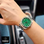 Replica Rolex Oyster Perpetual Green m124300 watch worn on the wrist, offering a stylish look with the striking green dial and durable Oystersteel case.