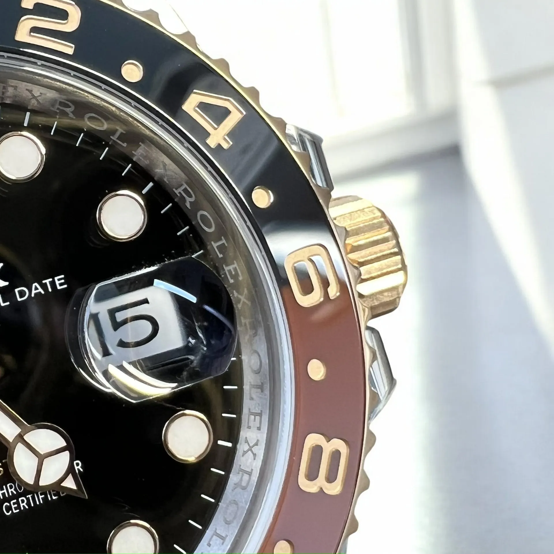 Super Clone Rolex GMT Root Beer 126711CHNR close-up of the black and brown ceramic bezel.