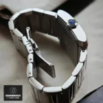 Mens super clone watch closeup: Cartier Tank Francaise WSTA0067 crown engraving and seamless case integration for water resistance