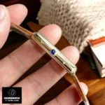 Side profile of Tank Louis-style watch dupe - Gold octagonal crown with synthetic blue spinel cabochon detail