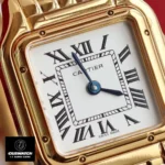 Close-up of the Panthere de Cartier gold WGPN0047 watch dupe's silvered dial with blued-steel sword-shaped hands.