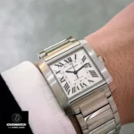 Close-up of the Cartier Tank Francaise WSTA0067 super clone watch dial while worn, highlighting the blued-steel sword-shaped hands and Roman numeral hour markers.