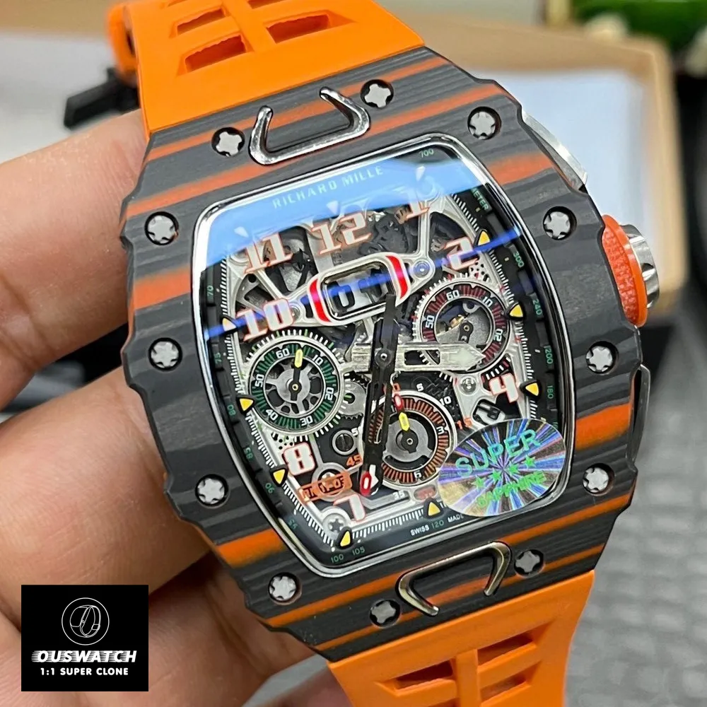 Close‑up of the Richard Mille RM 11‑03 McLaren dial: a Carbon TPT® base paired with yellow chronograph sub‑dials, hour markers coated in Chromalight® lume, and the McLaren collaboration logo engraved at 6 o’clock.