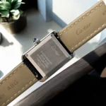 Engraved stainless steel case back of Cartier Tank Must WSTA0042 with serial number and "Swiss Made" certification.