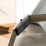 Detailed view of Cartier Tank Must WSTA0042's iconic blue synthetic spinel cabochon crown, symbolizing brand heritage