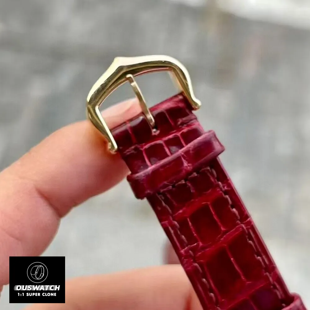 Close-up of the Ladies Cartier Santos WJSA0017 watch's rose gold ardillon pin buckle and shiny burgundy alligator leather strap.