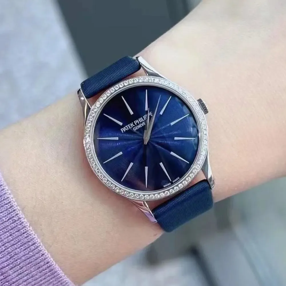 Patek Philippe Calatrava 4997/200G diamond bezel watch worn on a woman’s wrist, highlighting blue dial elegance.