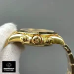Macro view of super clone Rolex Daytona 126508’s yellow-gold chronograph pushers and screw-down crown.