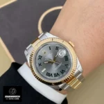 Rolex Datejust two-tone watch worn on wrist, featuring Oystersteel and yellow gold construction with fluted bezel.