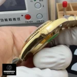 Crown close-up of the Rolex Day-Date 40 iced-out watch M228238, featuring yellow gold texture and fine detailing