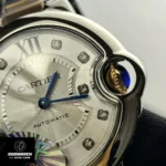 Macro shot of the Cartier Ballon Bleu crown and blue cabochon, highlighting the rose gold crown guard and finish.