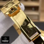 Macro detail of the yellow gold clasp on Rolex Submariner 126618LB-0002, showing polishing and engraving.