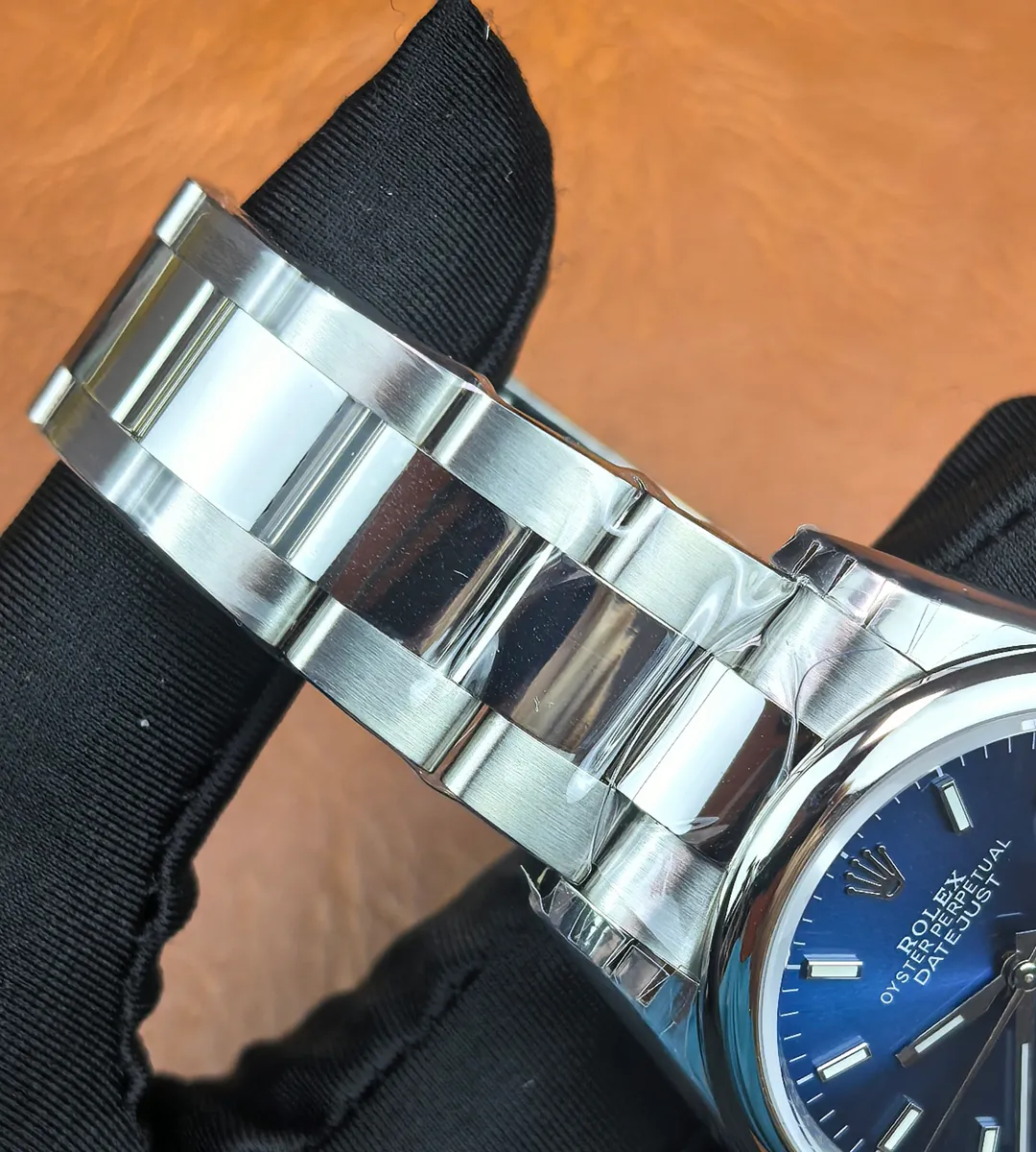Rolex Datejust 126200 36mm blue dial with 904L stainless steel bracelet displayed.