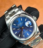 Rolex Datejust 36mm 126200-0006 blue dial shown at a 130° angle, showing bracelet and profile.