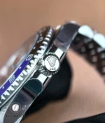 Macro of the stainless steel case and screw-down crown on the GMT-Master II Batgirl, showing machining and crown guards.