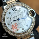 Detailed view of diamond bezel and silver dial on Cartier Ballon Bleu 33mm rose gold women's watch.