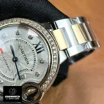 Partial close-up showing silver dial and two-tone bracelet on Cartier Ballon Bleu 33mm rose gold women's watch.