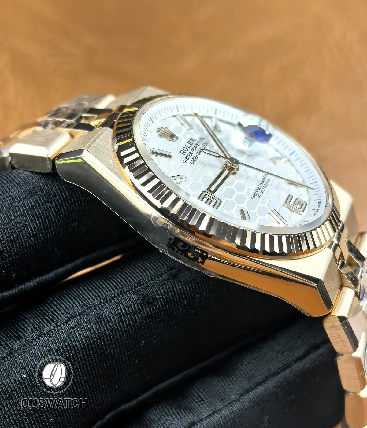 Close-up display of the rose gold case on Rolex Land-Dweller 127335-0001 highlighting polish and finishing.