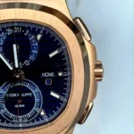 Macro shot of the blue sunburst dial and rose gold case of the 5990/1R Nautilus emphasizing texture and finishing.