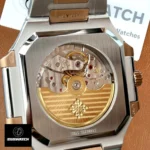 Detailed macro of the Patek Philippe Cubitus 5821/1AR movement components — gear train, balance, and decorative finishing.