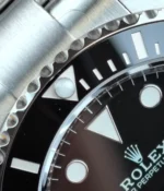 Close-up view of the 12 o’clock bezel marker on the Rolex Submariner 126610LN