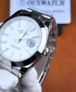 Angled close-up of the Rolex Datejust 126300 showing the winding crown, polished case, white dial, and Cyclops date magnifier.