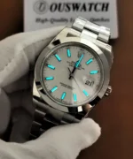 Close-up of the Rolex Datejust 41 126300 during a lume inspection, highlighting the blue glowing hour markers and hands.