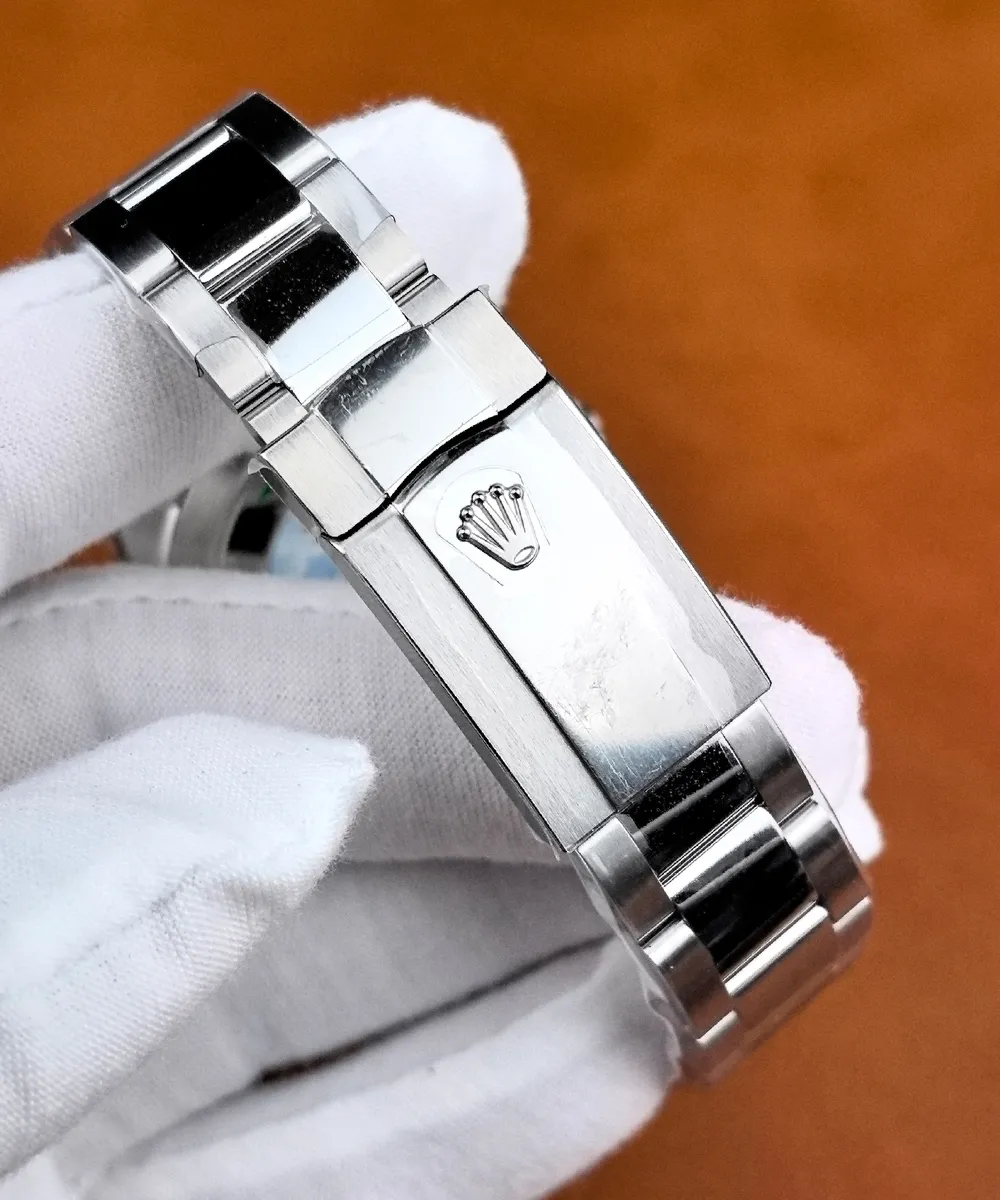 Close-up of the Rolex Datejust 126300 Oyster bracelet clasp, featuring the raised Rolex crown emblem and brushed steel surface.