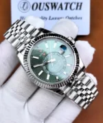 Three-quarter view of the Rolex Sky-Dweller 336934-0002 with a green sunburst dial, central 24-hour ring, fluted bezel, and Jubilee bracelet.